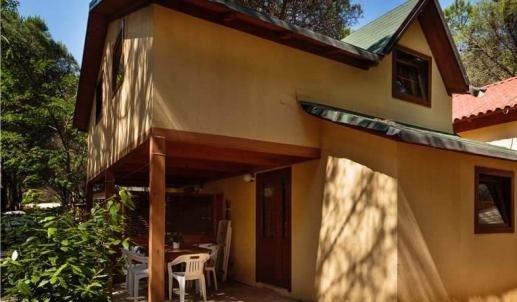 Casa gialla a due piani nel bosco.