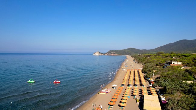 Spiaggia con ombrelloni e mare calmo.