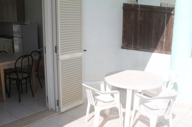 Tavolo rotondo e sedie di plastica su balcone.