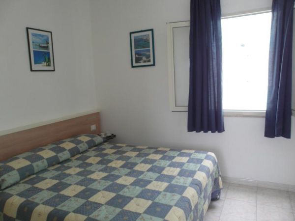 Camera con letto matrimoniale e tende blu.