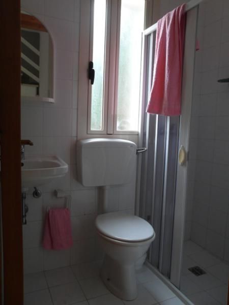 Bagno con doccia e asciugamani rosa.