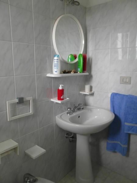 Lavabo con specchio e asciugamano blu.