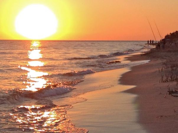 Tramonto su una spiaggia con onde.
