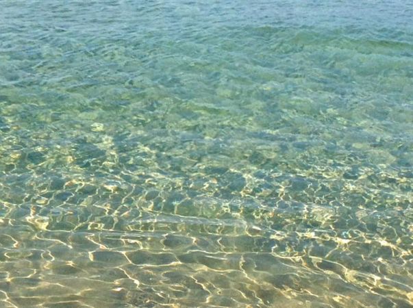 Acqua cristallina che riflette il sole.