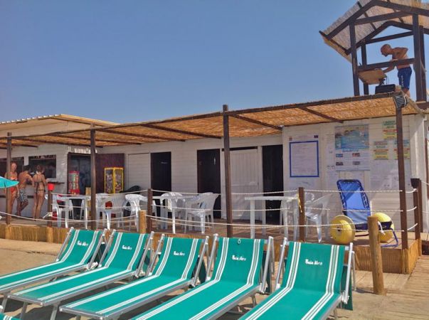 Lettini verdi e un piccolo chiosco sulla spiaggia.