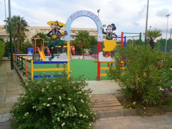 Un parco giochi per bambini, con entrata decorata da personaggi animati.