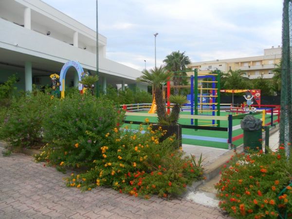 Un parco giochi colorato circondato da piante e fiori.