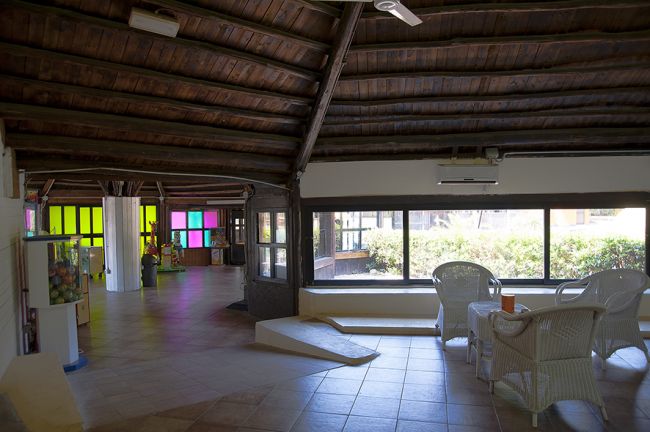 Interno di una sala con finestre e mobili in vimini.