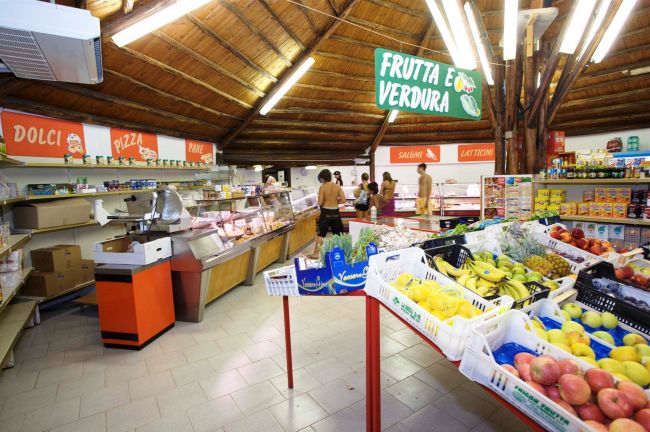 Interno di un supermercato con frutta e verdura in esposizione.
