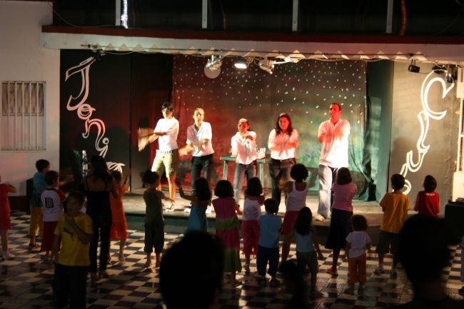 Intrattenimento sul palco con bambini che guardano.