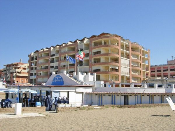 Palazzina vicino alla spiaggia con bandiere.