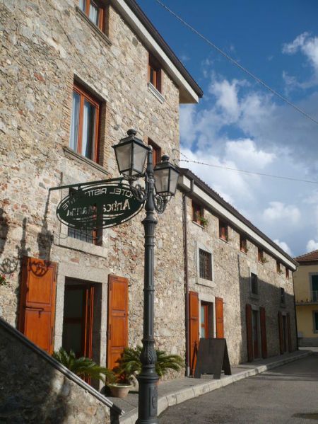 Edificio in pietra con insegna e lampione.