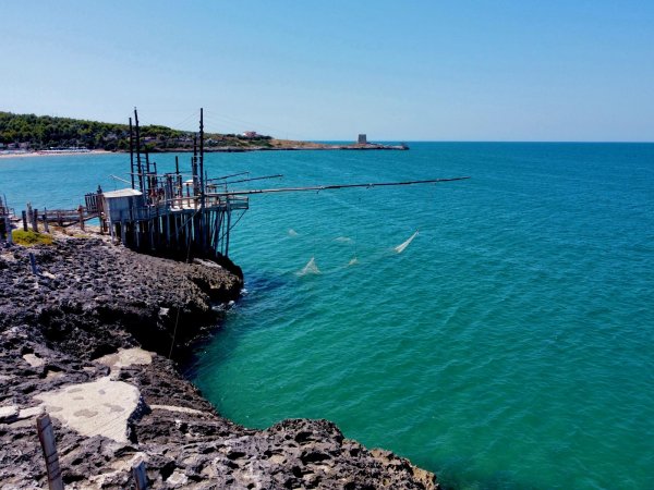 Scogliere con una struttura di legno per la pesca sul mare turchese.