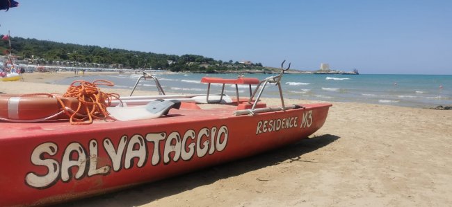 Barca di salvataggio rossa sulla spiaggia con scritta 