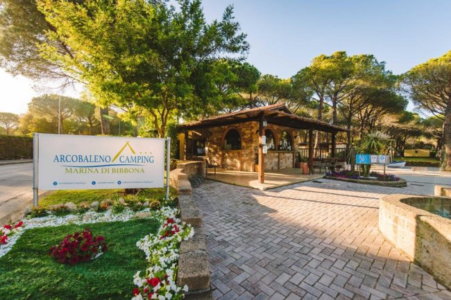 Ingresso di un campeggio circondato da pini.