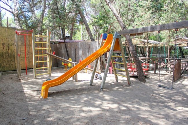 Un parco giochi con uno scivolo arancione.