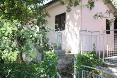 Casa rosa con alberi e una rampa di scale.