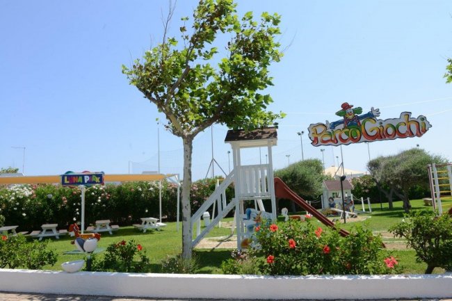Parco giochi con scivolo e panchine.