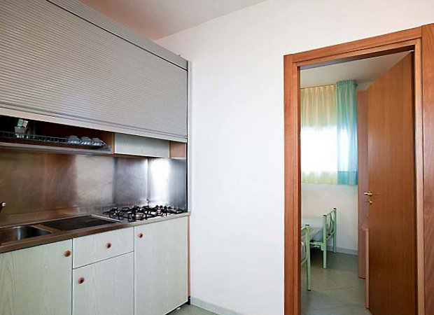 Angolo cottura moderno con porta in legno.