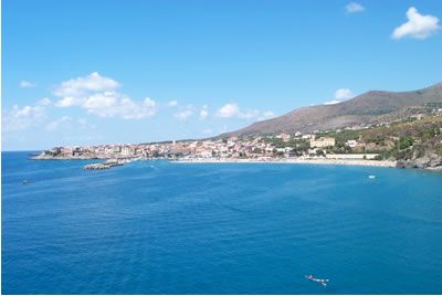 Vista panoramica del mare e di una città costiera con colline.