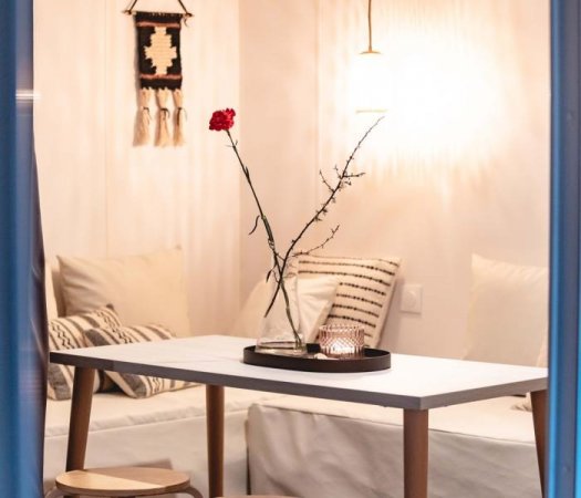 Interno accogliente con tavolo e decorazione floreale.