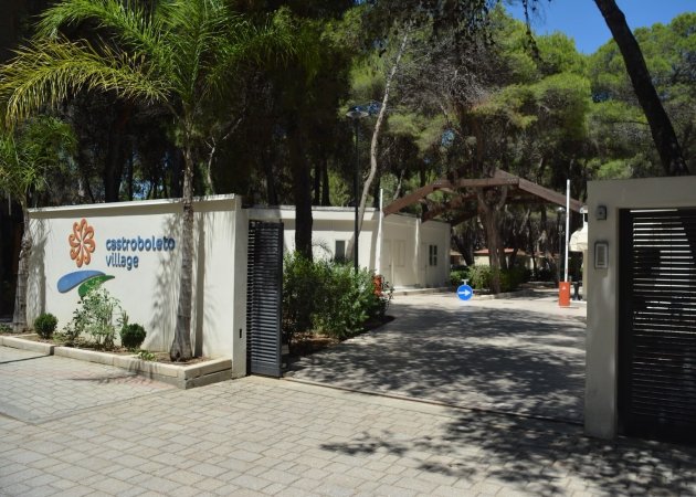 Ingresso al Castrobolleto Village con alberi.