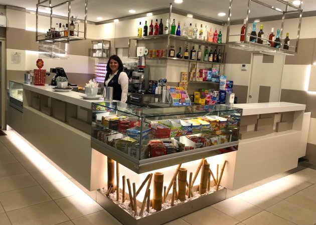 Donna dietro il bancone di un bar moderno.