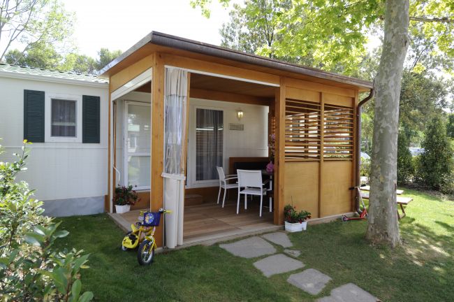 Casetta con veranda in legno e biciclette.