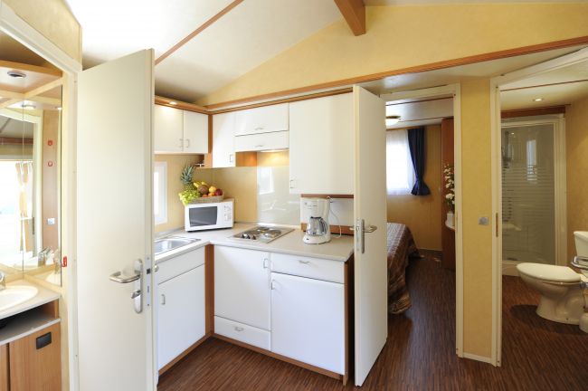 Cucina compatta con elettrodomestici e bagno a vista.