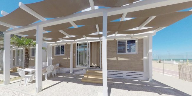 Casa mobile con pergolato e arredamento esterno.