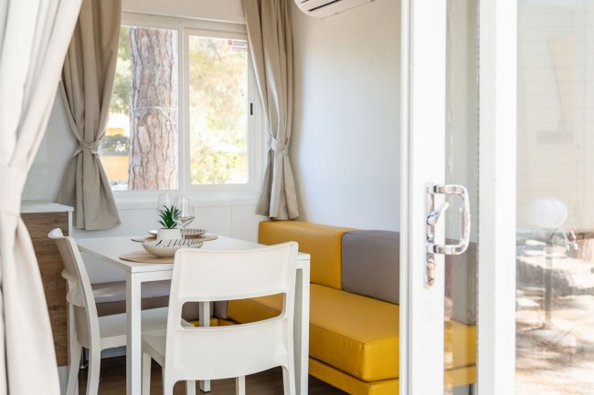 Interno di una stanza con tavolo e divano giallo.