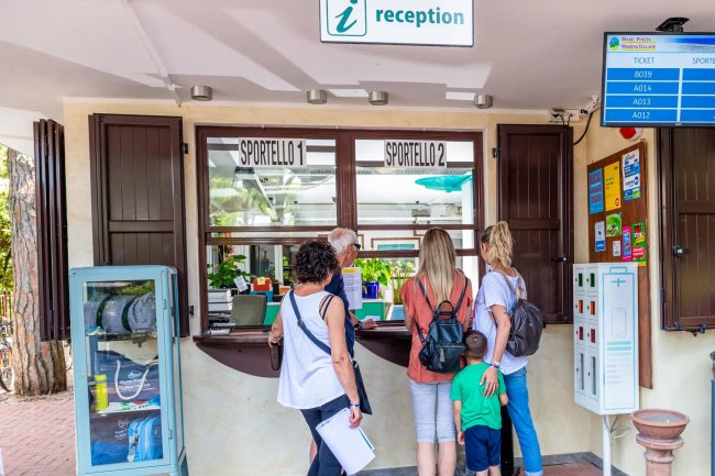 Persone in fila alla reception.