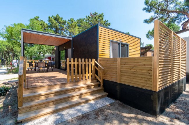 Casa mobile moderna con terrazza e recinzione in legno.