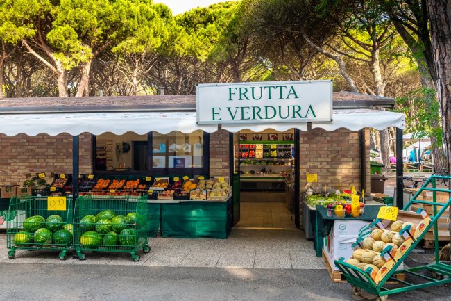 Negozio di frutta e verdura con frutta esposta fuori.