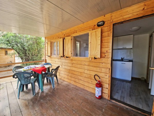 Veranda in legno con tavolo e sedie.