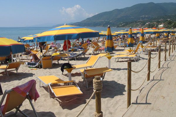 Spiaggia con lettini e ombrelloni gialli.