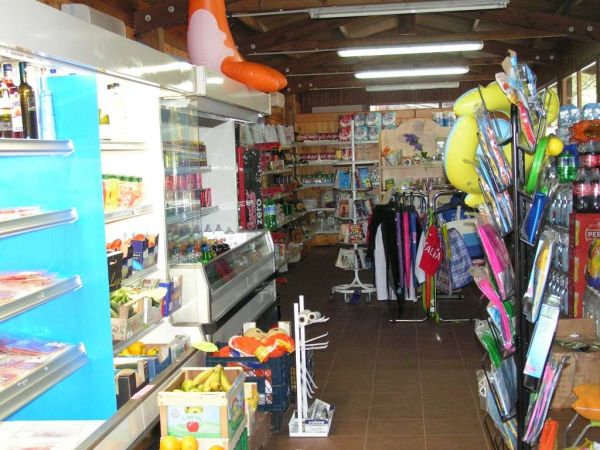 Un negozio con scaffali pieni di prodotti alimentari, pannelli blu e articoli vari.