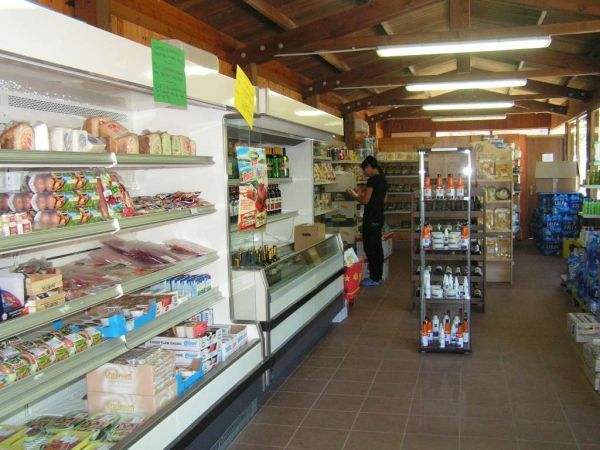 Interno di un minimarket con scaffali pieni di prodotti.