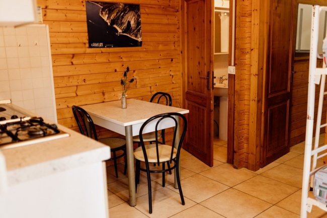 Cucina con tavolo da pranzo e sedie, accanto a un bagno.