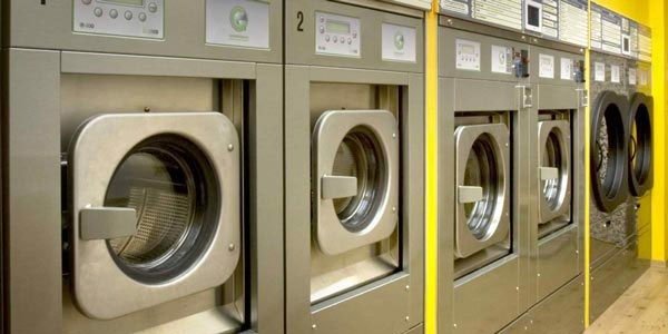 File di lavatrici industriali in una lavanderia.